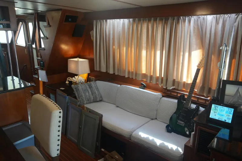God's Favor Yacht Photos Pics 1986 DeFever 53 POC yacht interior with cozy seating, guitar, and nautical decor.