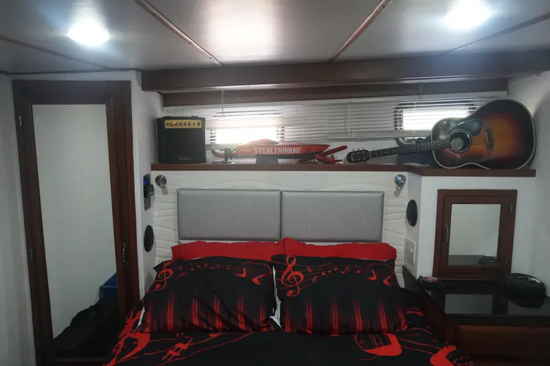 God's Favor Yacht Photos Pics Cozy bedroom in 1986 DeFever 53 POC yacht with musical decor and guitar.
