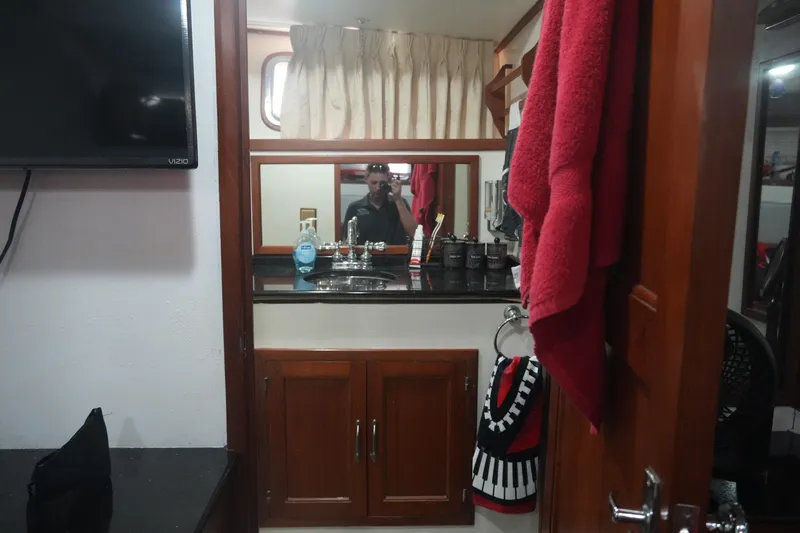 God's Favor Yacht Photos Pics Bathroom interior of 1986 DeFever 53 POC yacht with mirror and wooden cabinets.