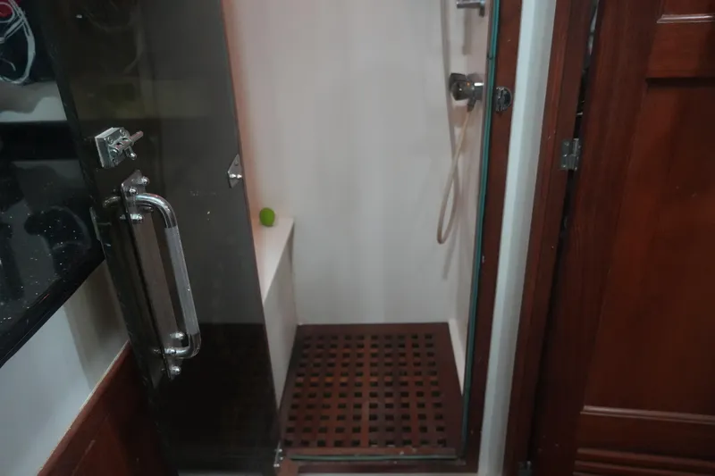 God's Favor Yacht Photos Pics Shower area in 1986 DeFever 53 POC yacht with glass door and wooden floor.