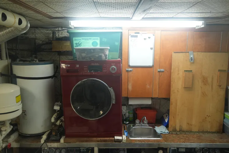 God's Favor Yacht Photos Pics Laundry area on 1986 DeFever 53 POC yacht with washer, sink, and storage cabinets.