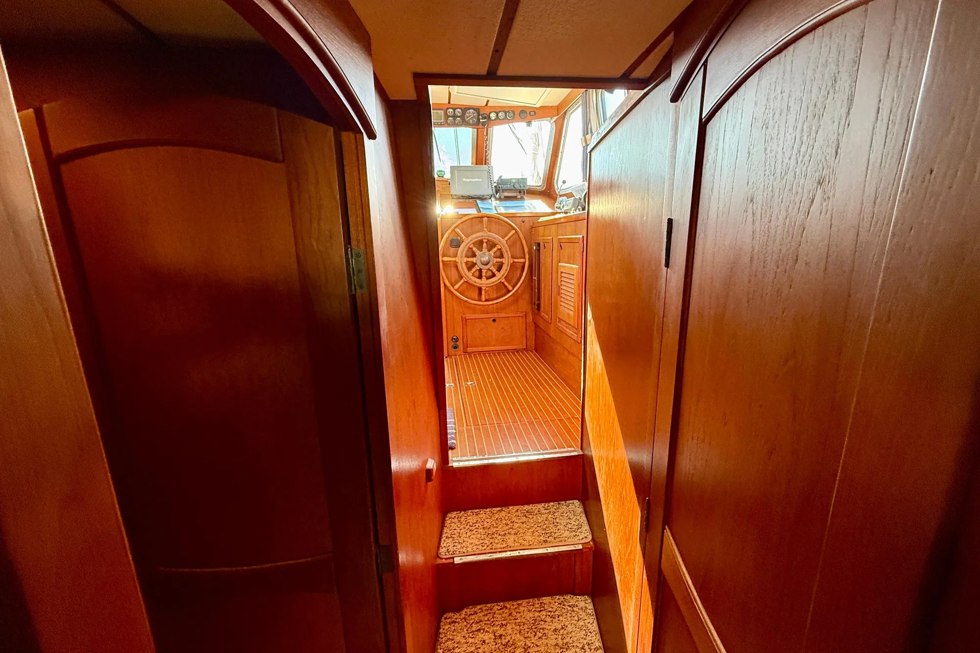 Interior of 1986 Nauticat 43 sailboat with wooden helm and cabinetry.