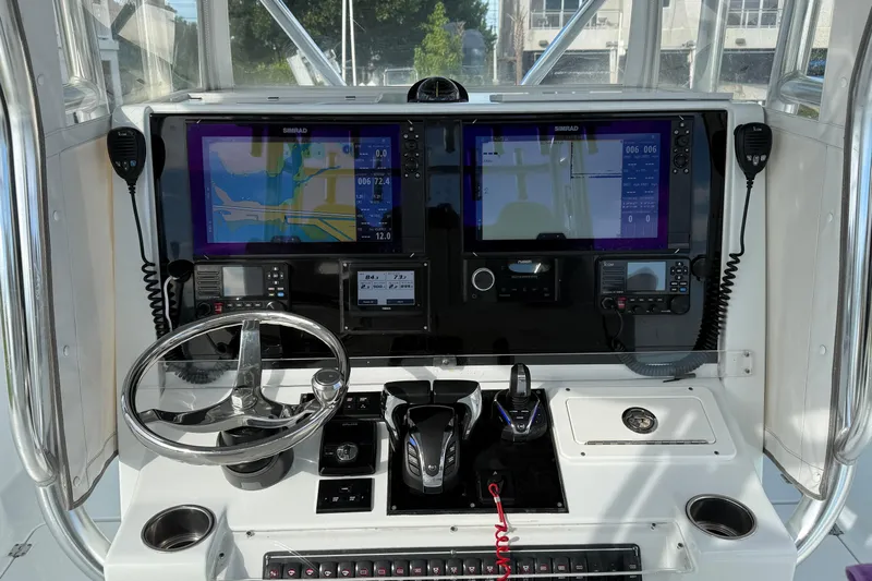  Yacht Photos Pics Control panel of a 2022 Freeman 34VH boat with navigation screens and steering wheel.