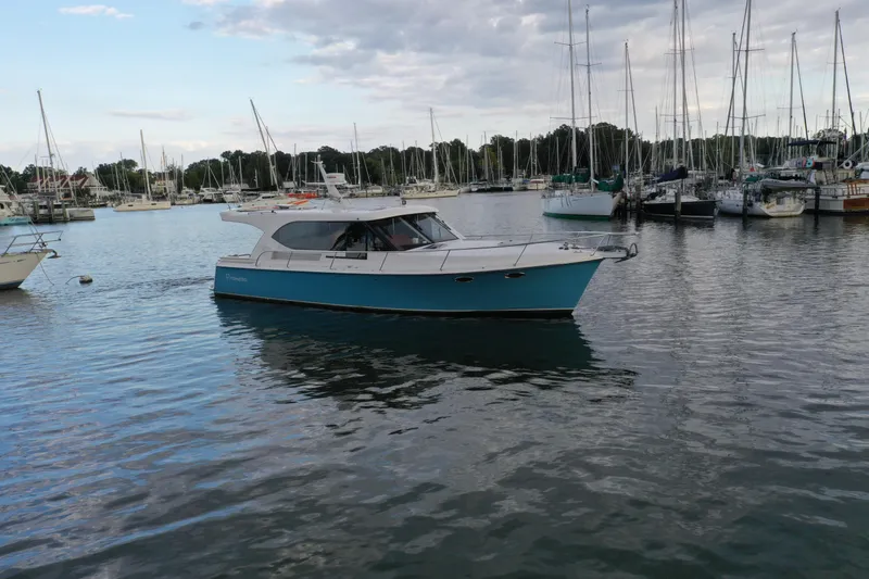 Promesa Yacht Photos Pics 2021 Hylas M44 yacht cruising in a marina with sailboats in the background.