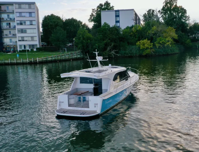 Promesa Yacht Photos Pics Hylas M44 yacht cruising on a calm river near residential buildings, 2021 model.