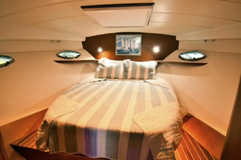 Promesa Yacht Photos Pics Cozy cabin interior of 2021 Hylas M44 yacht with striped bedding and nautical decor.