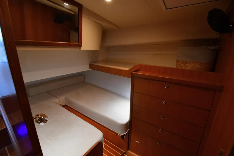 Promesa Yacht Photos Pics Interior of 2021 Hylas M44 yacht cabin with wooden furnishings and cozy bedding.