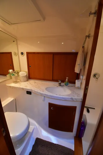 Promesa Yacht Photos Pics 2021 Hylas M44 yacht bathroom with wooden cabinets and marble countertop.