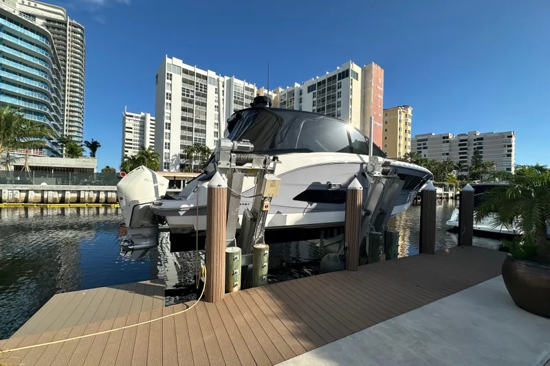 Jet Privé Yacht Photos Pics 2021 Searay 370ob boat docked in a marina with cityscape background.