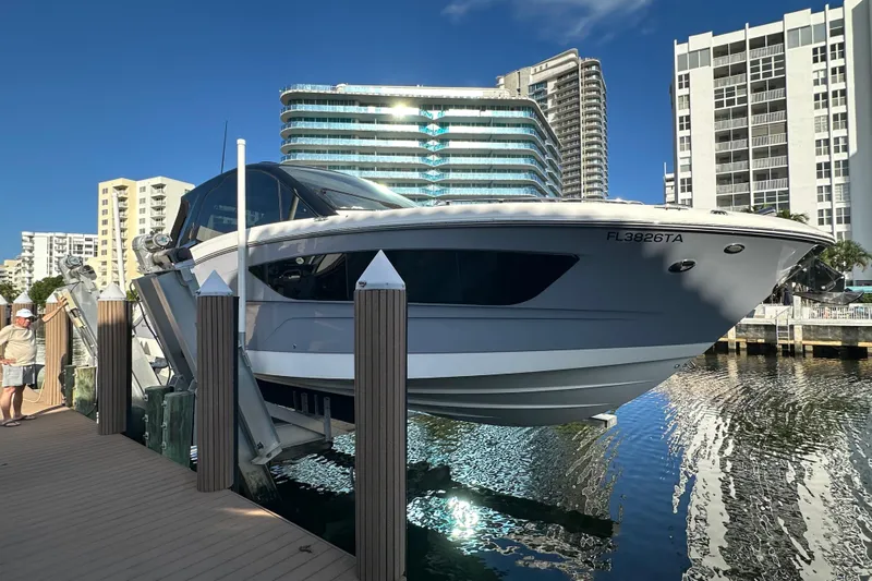 Jet Privé Yacht Photos Pics 2021 Searay 370ob boat docked in urban marina with modern buildings.