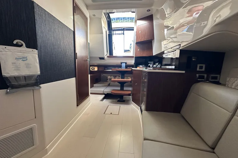 Jet Privé Yacht Photos Pics 2021 Searay 370ob boat interior with modern kitchen and seating area.