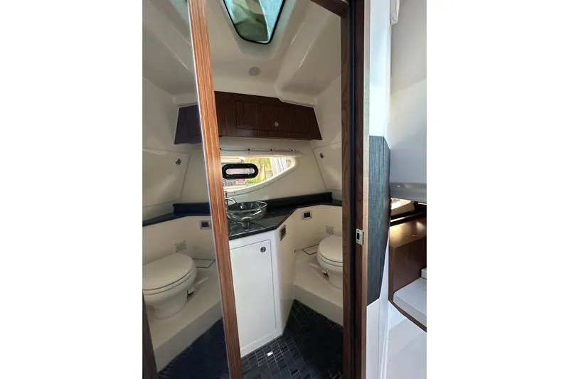 Jet Privé Yacht Photos Pics Luxurious 2021 Searay 370ob boat bathroom with modern fixtures and wood accents.