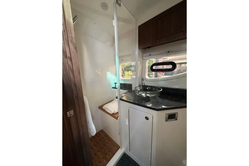 Jet Privé Yacht Photos Pics 2021 Searay 370ob boat bathroom with glass sink and wooden accents.