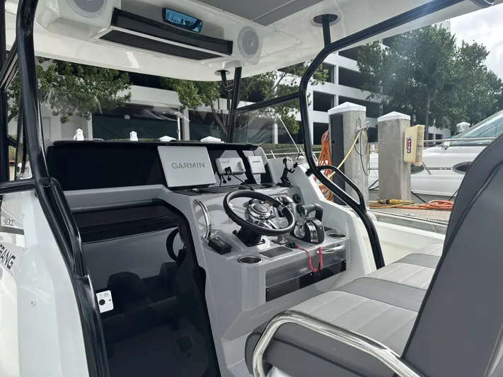 Jebang Yacht Photos Pics 2023 Jeanneau Leader 9.0 CC helm with Garmin navigation, docked at marina.