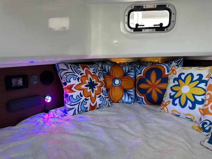 Jebang Yacht Photos Pics Cozy cabin interior of 2023 Jeanneau Leader 9.0 CC with colorful floral pillows.