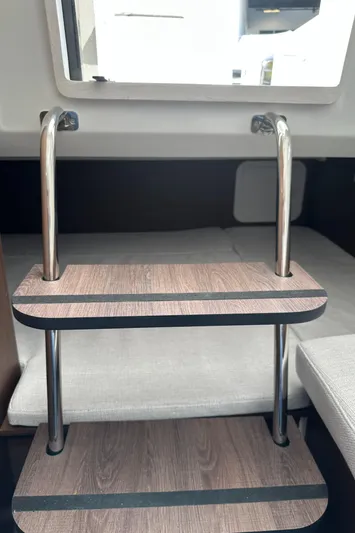 Jebang Yacht Photos Pics Interior view of 2023 Jeanneau Leader 9.0 CC boat with wooden steps and metal railings.