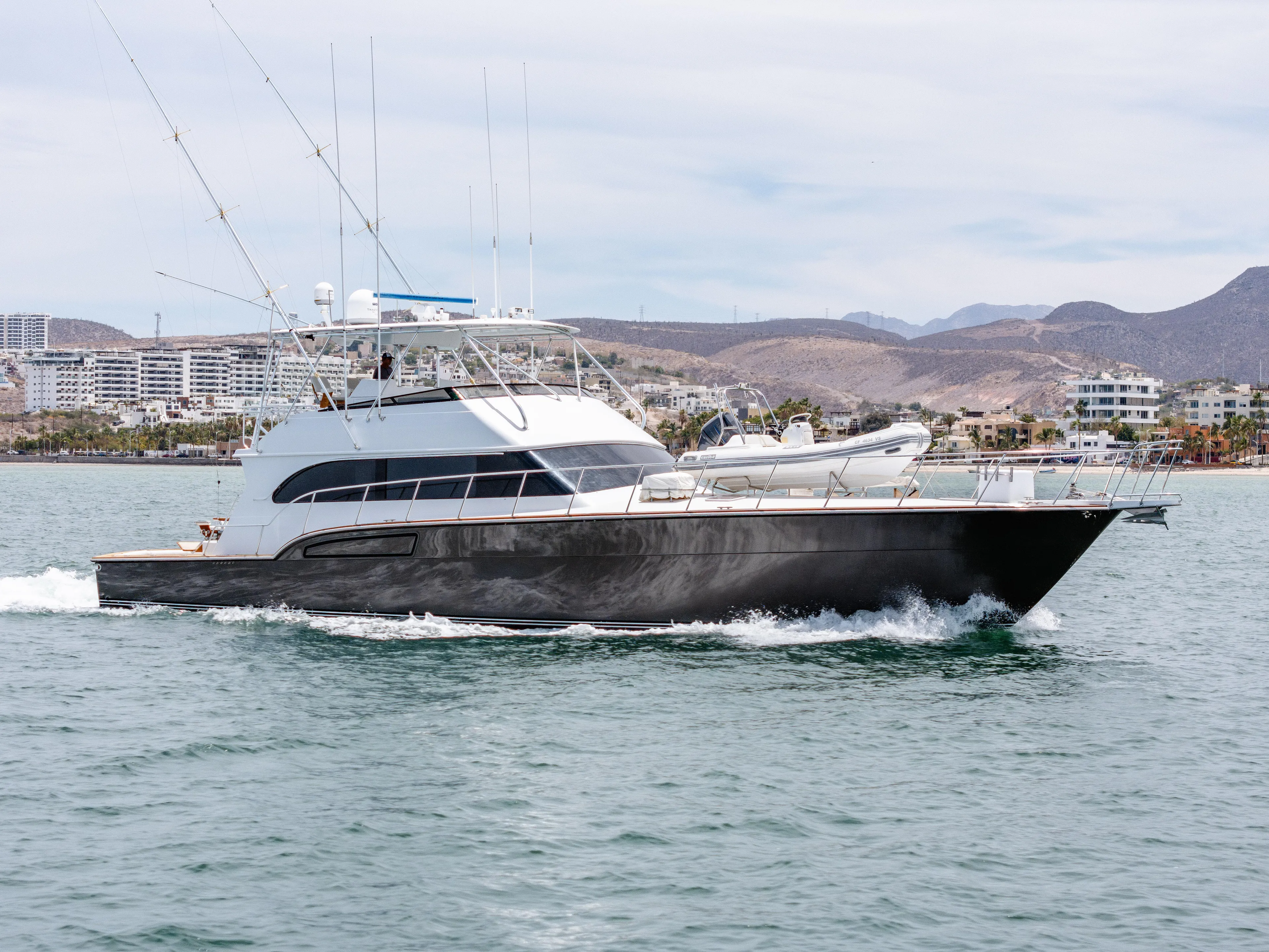 Tiger Spirit Yacht Photos Pics 1995 Donzi 72 Convertible yacht cruising on water with coastal cityscape backdrop.
