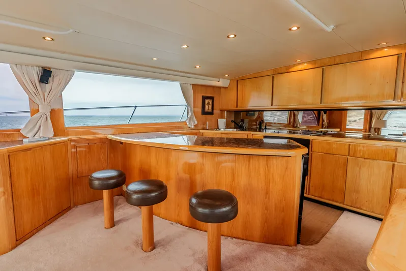 Tiger Spirit Yacht Photos Pics Luxurious interior of a 1995 Donzi 72 Convertible yacht with wooden cabinetry and bar stools.