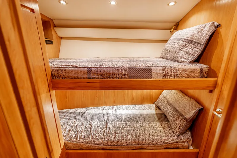 Tiger Spirit Yacht Photos Pics Bunk beds in 1995 Donzi 72 Convertible yacht cabin with wood paneling and cozy lighting.
