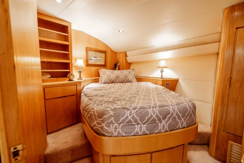 Tiger Spirit Yacht Photos Pics Luxurious bedroom interior of 1995 Donzi 72 Convertible yacht with cozy bed and wooden furnishings.