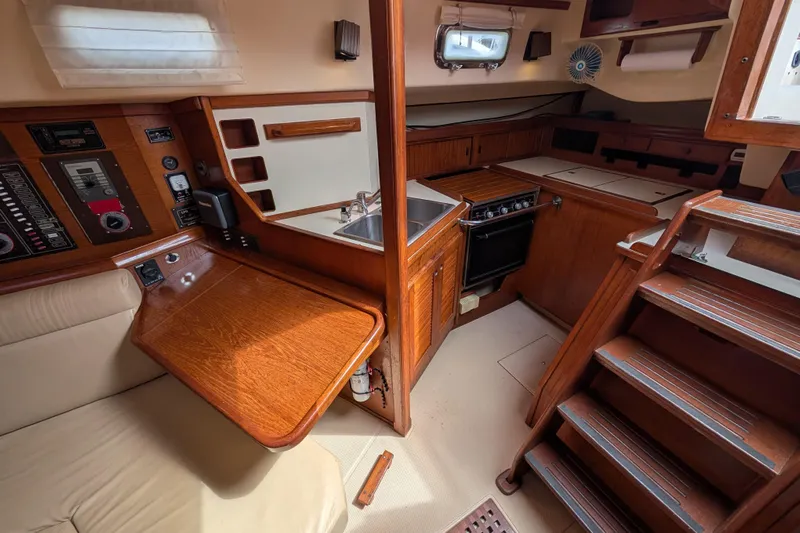 Lone Star Yacht Photos Pics 1988 Island Packet 38 interior with wooden cabinetry, kitchen, and navigation station.