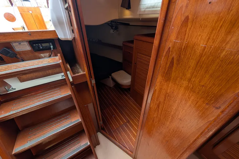 Lone Star Yacht Photos Pics Interior of 1988 Island Packet 38 sailboat, featuring wooden stairs and cabin area.
