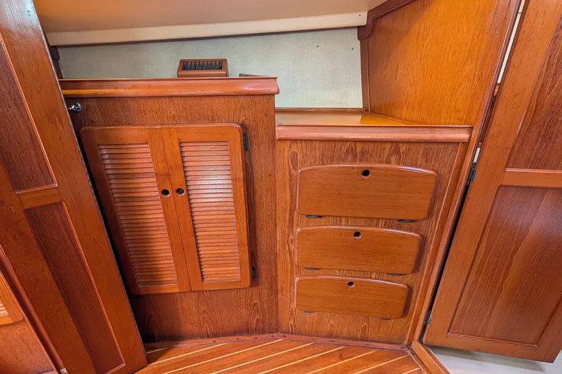 Lone Star Yacht Photos Pics 1988 Island Packet 38 interior with wooden cabinetry and storage drawers.