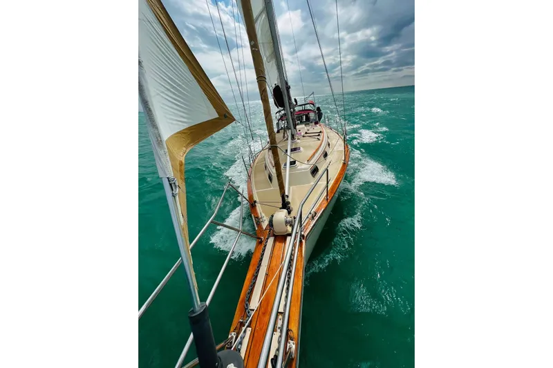 Lone Star Yacht Photos Pics 1988 Island Packet 38 sailboat navigating turquoise waters under cloudy skies.