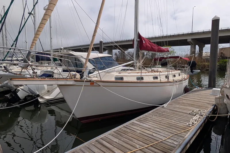 Lone Star Yacht Photos Pics 1988 Island Packet 38 sailboat docked at marina with red sails and wooden deck.
