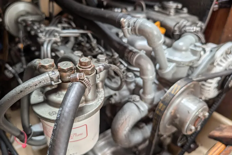 Lone Star Yacht Photos Pics Engine components of a 1988 Island Packet 38 sailboat, showcasing hoses and mechanical parts.