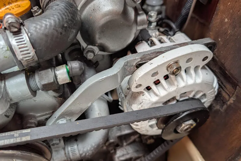 Lone Star Yacht Photos Pics Engine components of a 1988 Island Packet 38 sailboat, featuring alternator and belt system.