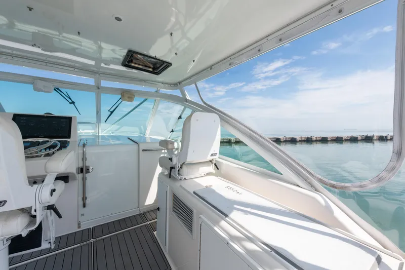  Yacht Photos Pics 2004 Cabo 40 Express yacht interior with helm, overlooking calm sea and clear sky.
