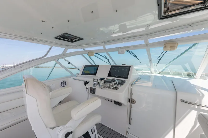  Yacht Photos Pics Helm of 2004 Cabo 40 Express yacht with modern navigation equipment and white seating.