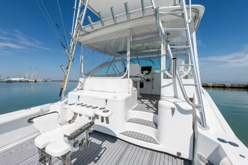  Yacht Photos Pics 2004 Cabo 40 Express yacht with fishing gear, docked in a serene marina.