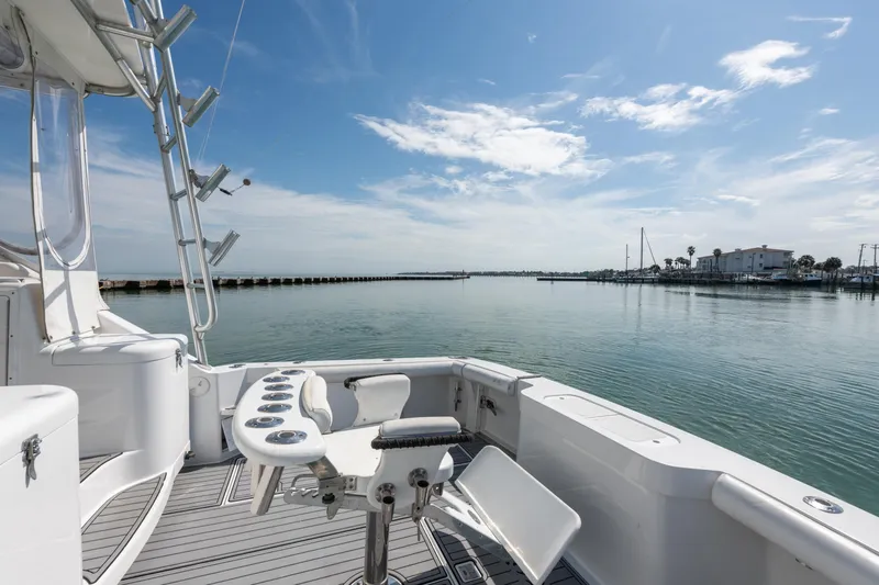  Yacht Photos Pics 2004 Cabo 40 Express yacht deck with fishing setup, overlooking calm waters and clear sky.