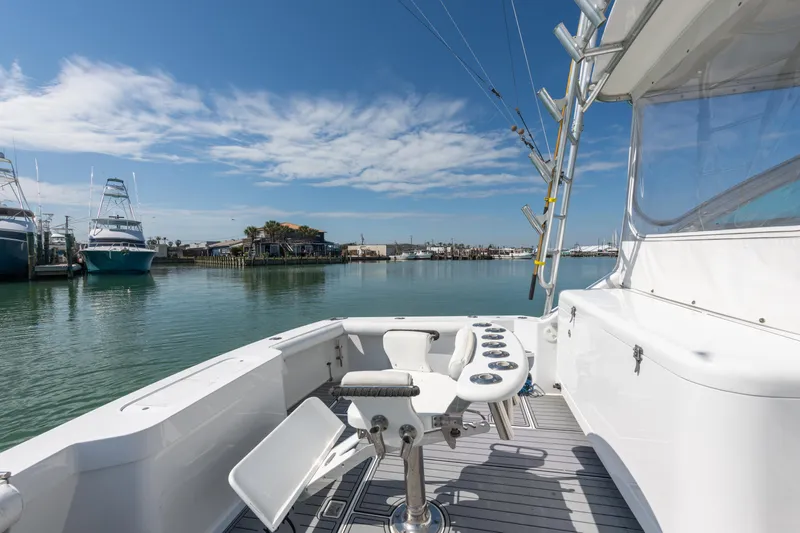  Yacht Photos Pics 2004 Cabo 40 Express yacht with fishing setup, docked in a serene marina.