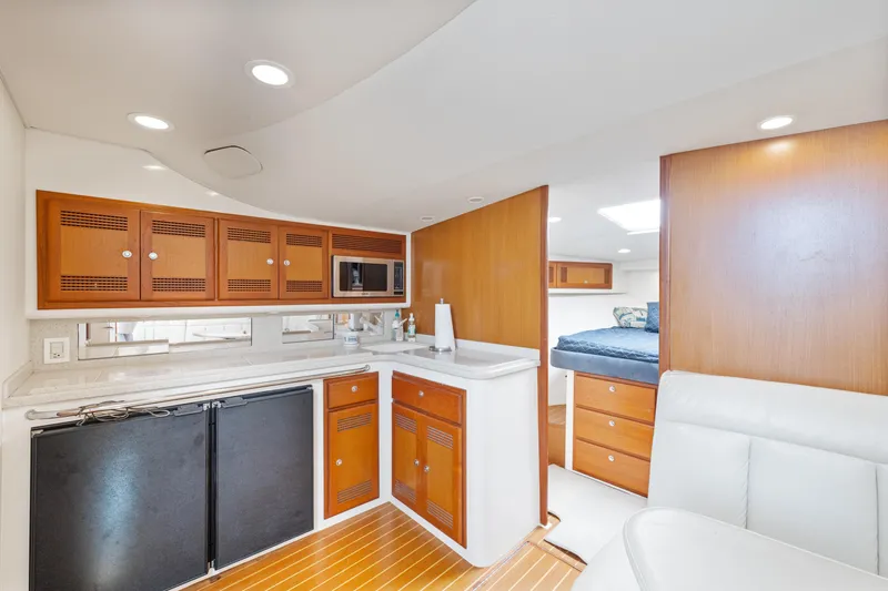  Yacht Photos Pics 2004 Cabo 40 Express yacht interior with modern kitchen and cozy sleeping area.