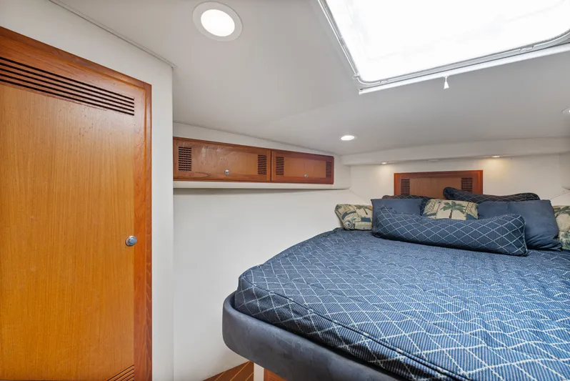  Yacht Photos Pics Interior cabin of 2004 Cabo 40 Express yacht with bed and wooden storage.