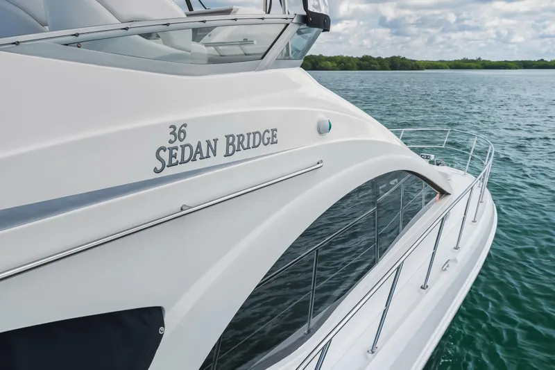 Deep Blue Yacht Photos Pics 2008 Sea Ray 36 Sedan Bridge yacht on calm water, showcasing sleek design and elegance.