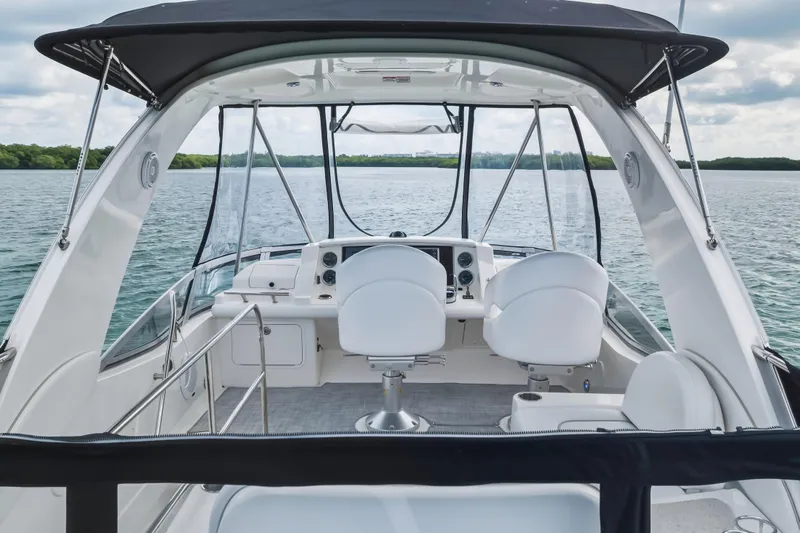 Deep Blue Yacht Photos Pics 2008 Sea Ray 36 Sedan Bridge yacht interior with helm, white seating, and water view.