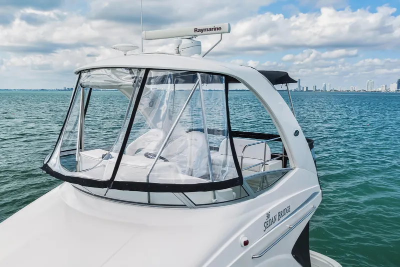 Deep Blue Yacht Photos Pics 2008 Sea Ray 36 Sedan Bridge yacht on open water with city skyline.
