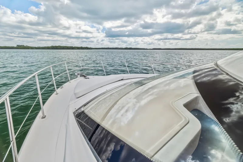 Deep Blue Yacht Photos Pics 2008 Sea Ray 36 Sedan Bridge yacht cruising on a serene lake under a cloudy sky.