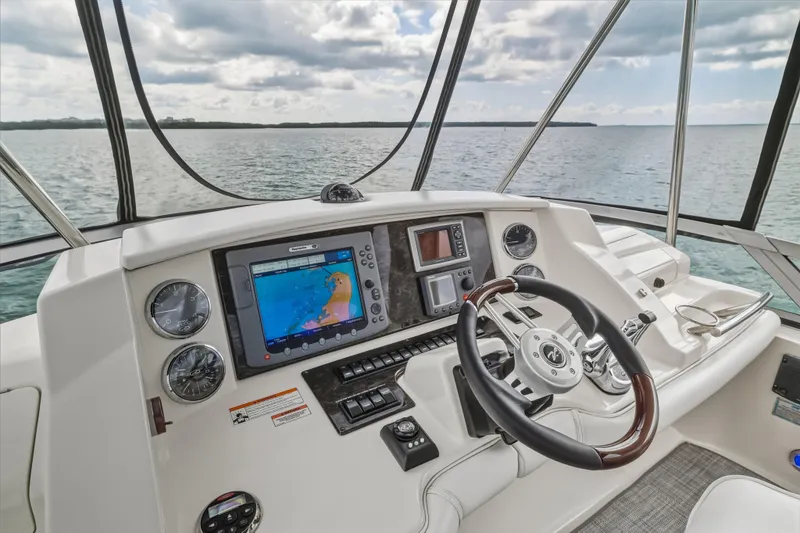 Deep Blue Yacht Photos Pics 2008 Sea Ray 36 Sedan Bridge helm with navigation system and steering wheel, overlooking calm waters.
