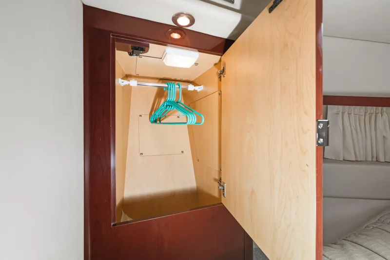 Deep Blue Yacht Photos Pics Open wooden closet with hangers inside a 2008 Sea Ray 36 Sedan Bridge yacht.