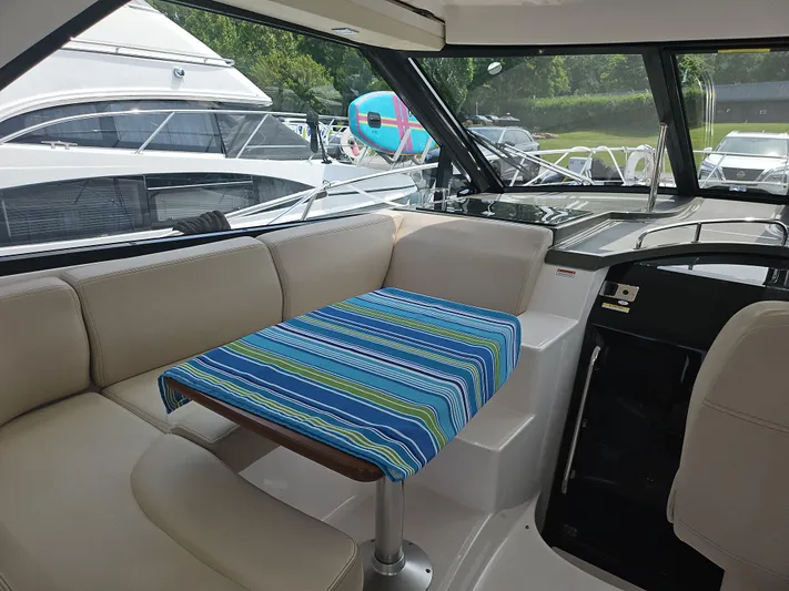  Yacht Photos Pics Interior of 2011 Regal 42 Sport Coupe with striped table cover and beige seating.