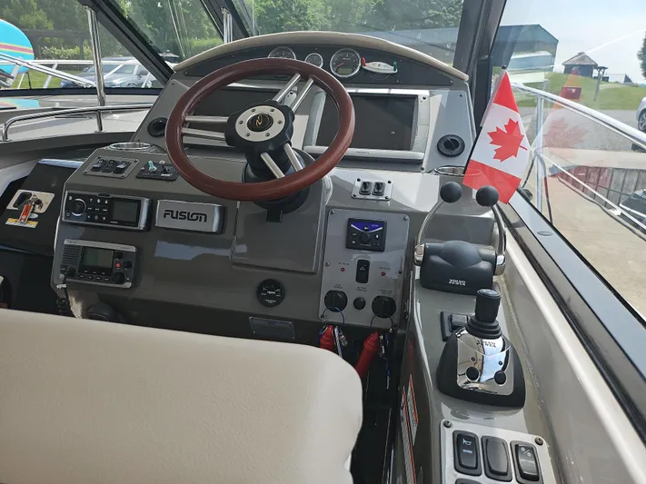  Yacht Photos Pics 2011 Regal 42 Sport Coupe helm with Canadian flag, featuring advanced controls and navigation systems.
