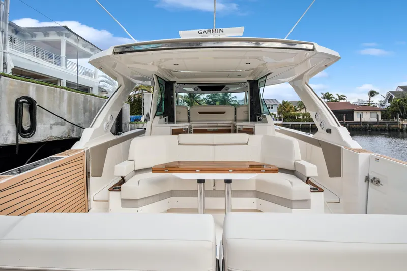  Yacht Photos Pics 2022 Tiara Yachts 48 LS luxury boat interior with seating and table, docked by waterfront homes.