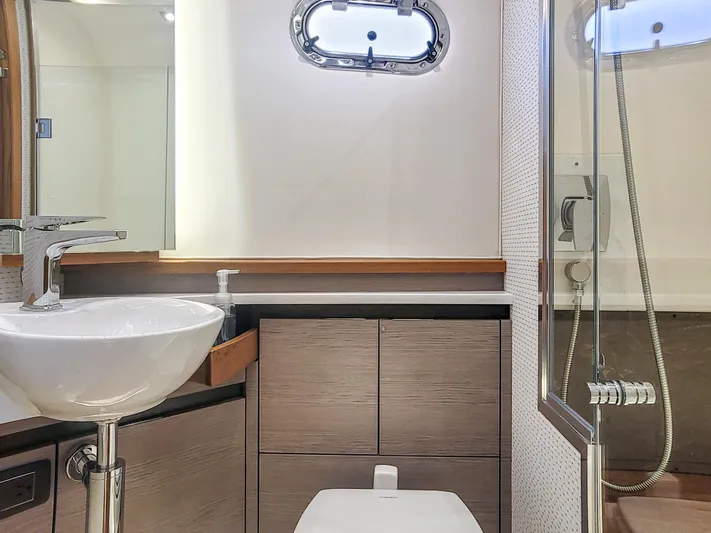  Yacht Photos Pics Modern bathroom in 2022 Tiara Yachts 48 LS, featuring sleek sink and shower.