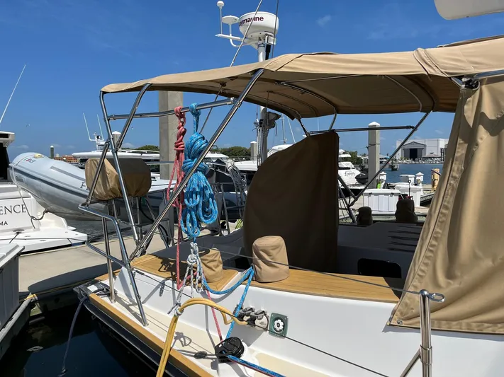 Sapphire Yacht Photos Pics Tartan 4700 sailboat, 2014 model, docked at marina with beige canopy and ropes.