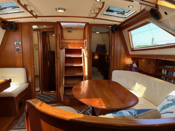 Sapphire Yacht Photos Pics Interior of a 2014 Tartan 4700 sailboat with wooden furnishings and cozy seating area.